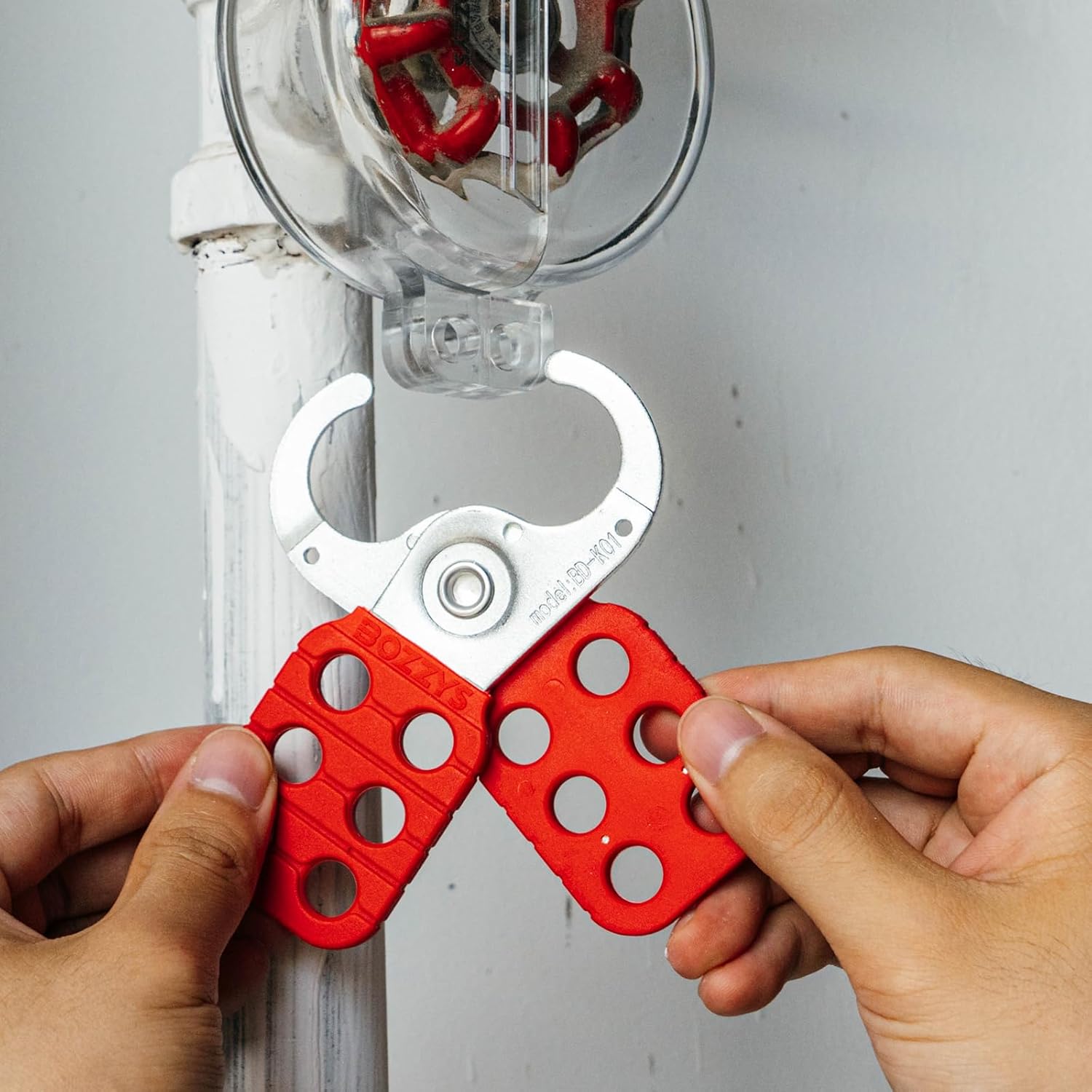 OSHA Compliant LOTO safety hasp, red plastic and metal, in use by BOZZYS Factory