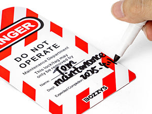 OSHA Compliant LOTO safety tag, red and white plastic, being written on, by BOZZYS Factory